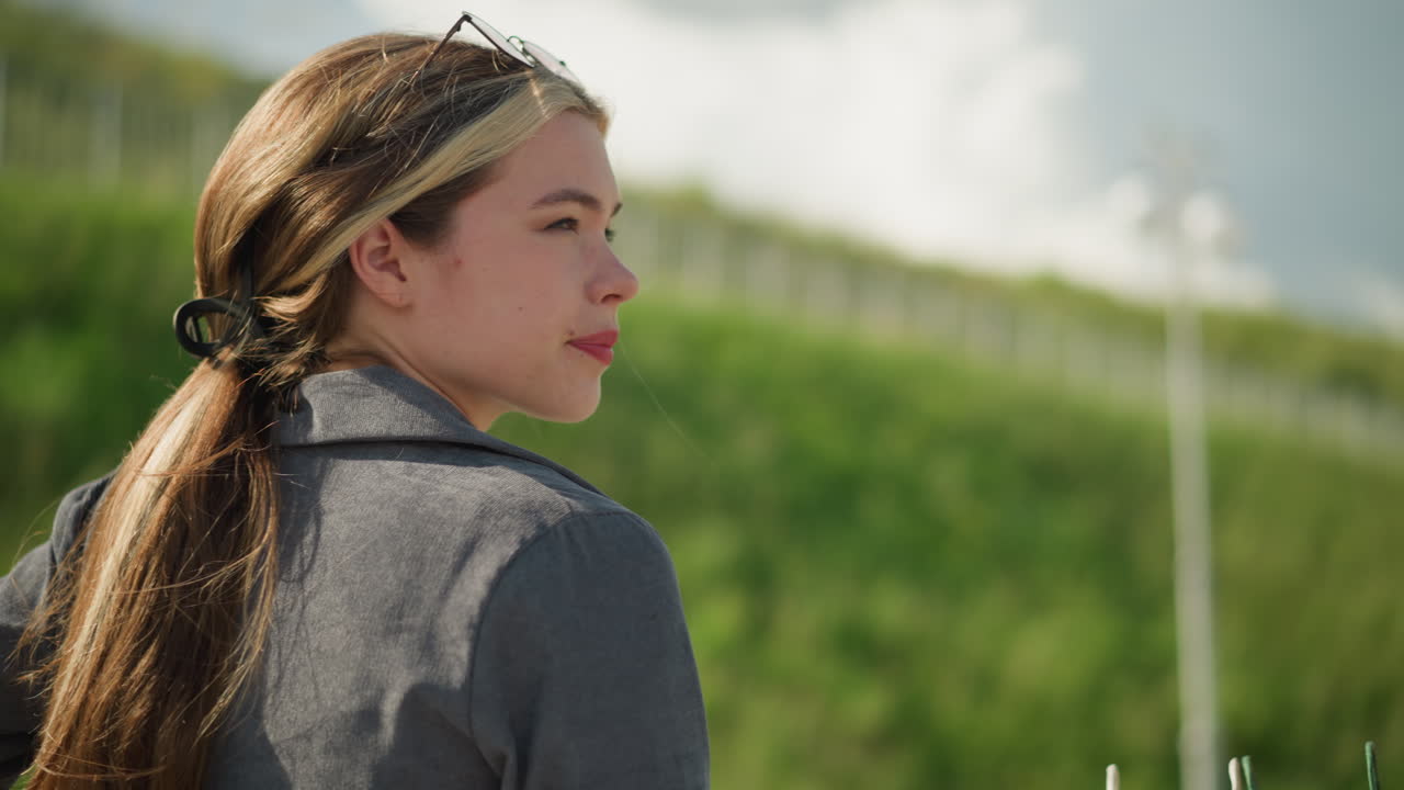 머리에 선글라스를 착용한 회색 을 입은 사려 깊은 여자의 클로즈업, 멀리 쳐다보고, 야외에 앉아