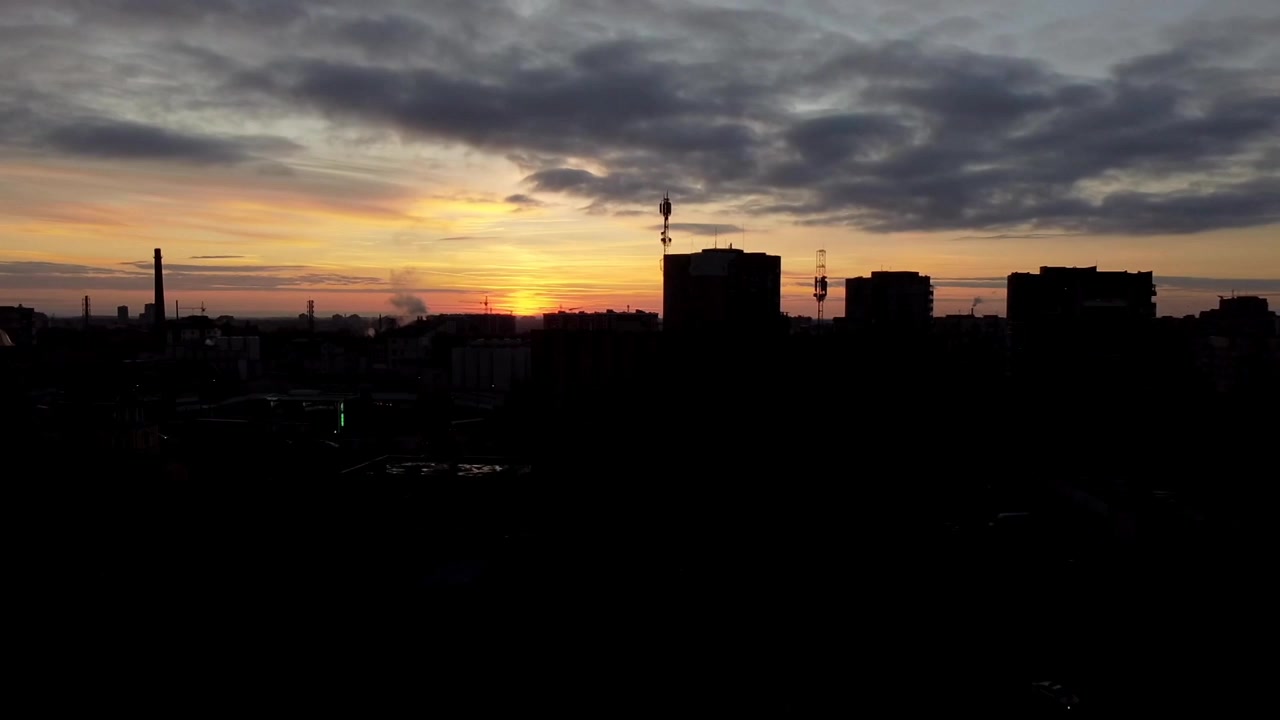 Vista aérea de un dron volando sobre la ciudad. Atardecer en el cielo
