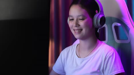 close up of excited asian teen girl gamer celebrates victory and dancing while playing video game on computer