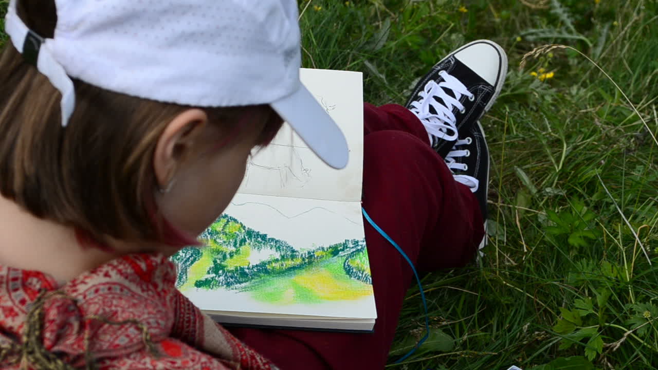 Gadis itu menggambar pemandangan gunung langsung dari alam. Gambar itu dibuat menggunakan pastel.
