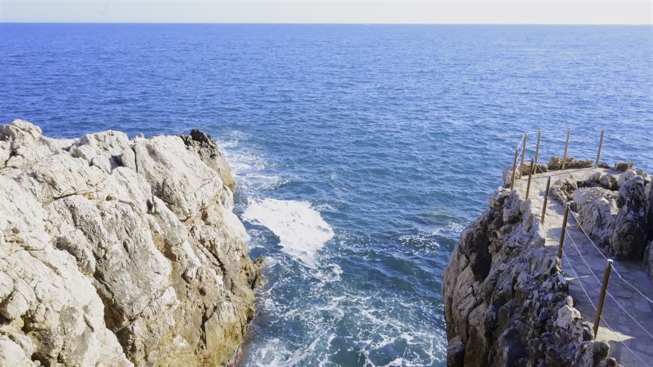 The waves of the Mediterranean Sea crashing on the rocks on the shore of the French Riviera