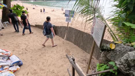 beach scene with people and bamboo fence