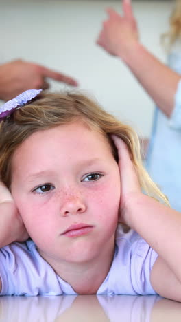 niña pequeña bloqueando el ruido de los padres peleando