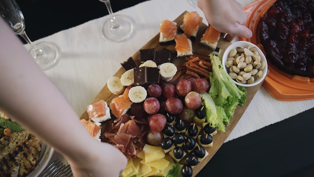 la chica gira la bandeja de golosinas en la mesa para hacer espacio para otras golosinas. disparando preparaciones para la cena