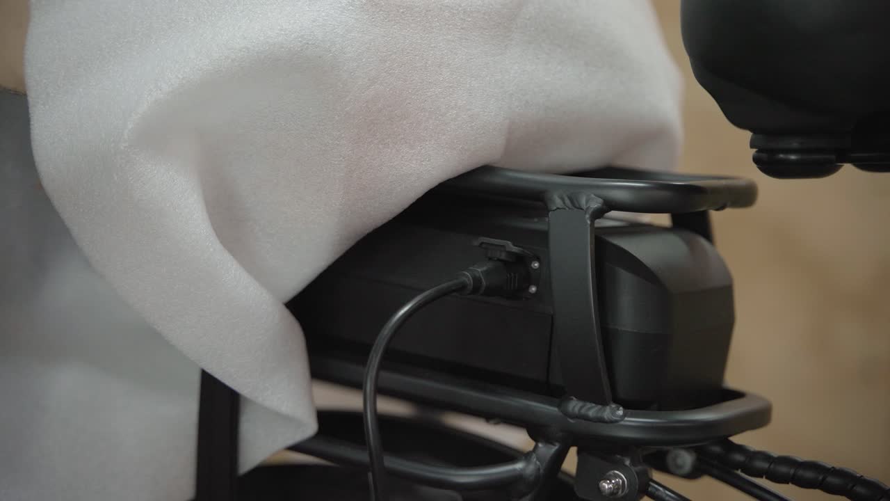 남자는 배터리를 충전하기 위해 전기 자전거의 배터리에 코드를 연결합니다.