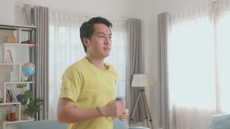 Asian Man Running On A Treadmill At Home