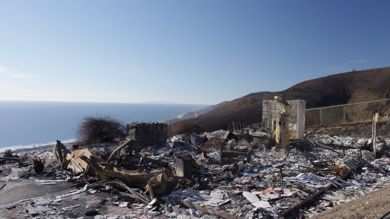 casa quemada en la ladera de malibu con el océano al fondo