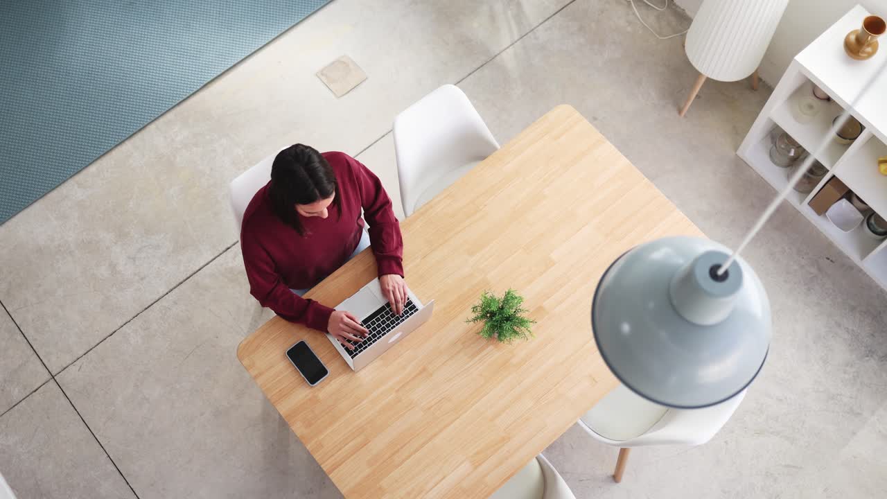 Overhead View of Woman Typing on Laptop at Modern Desk