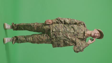 full body of asian man soldier talking on smartphone and looking around while standing in the green screen background studio