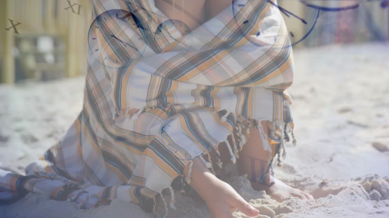 Mädchen kniet, gräbt im Sand, Kamera fährt zurück, Mädchen richtet Tuch/Wickel zurecht, Uhr über dem Mädchen zeigt Gesundheitsdaten an.
