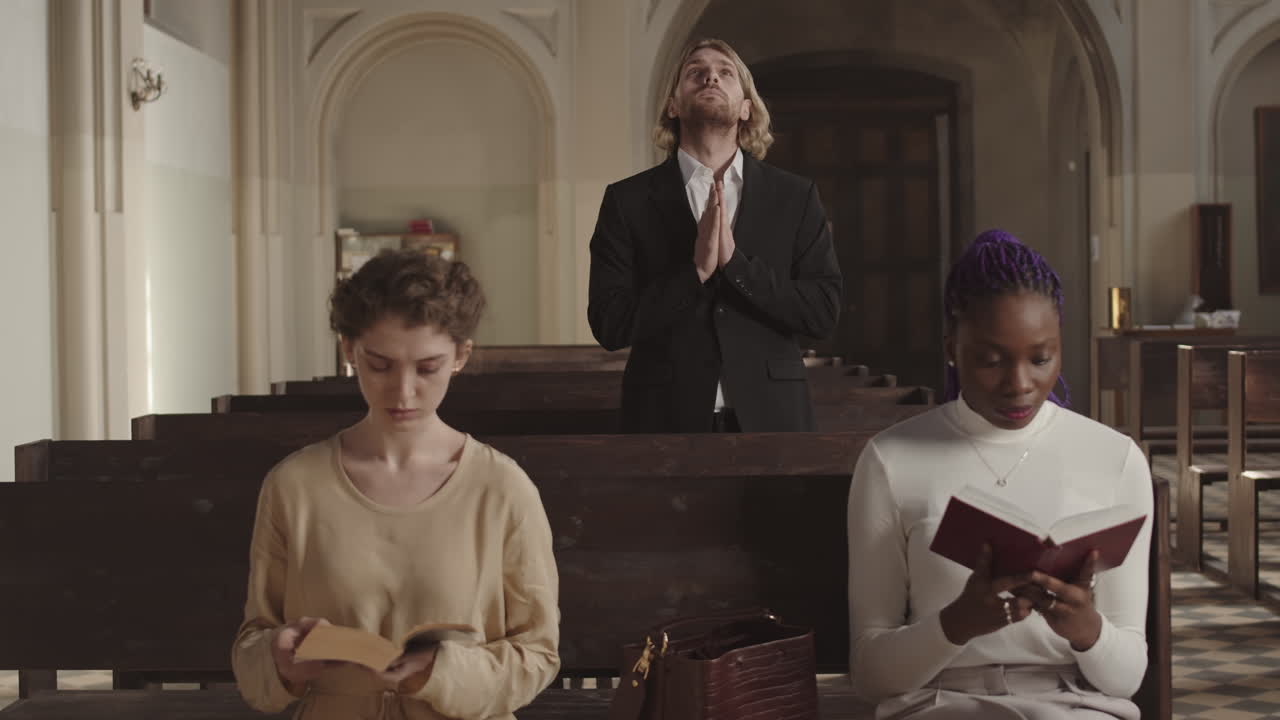 Three Young Diverse Parishioners Praying in Christian Church