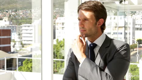 thoughtful businessman looking out window