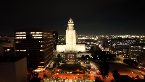 los angeles, california at night with city hall illuminated - rising aerial reveal