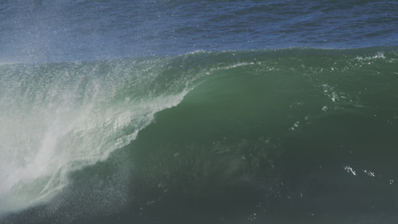 Slow-motion ocean wave rolling in during golden hour, capturing the natural beauty and dynamic motion of the water.