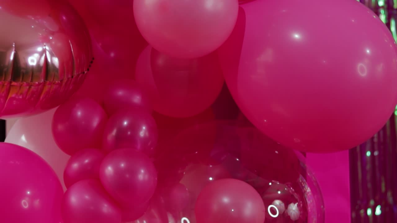 globos rosados contra un telón de fondo brillante, creando una atmósfera festiva y lúdica