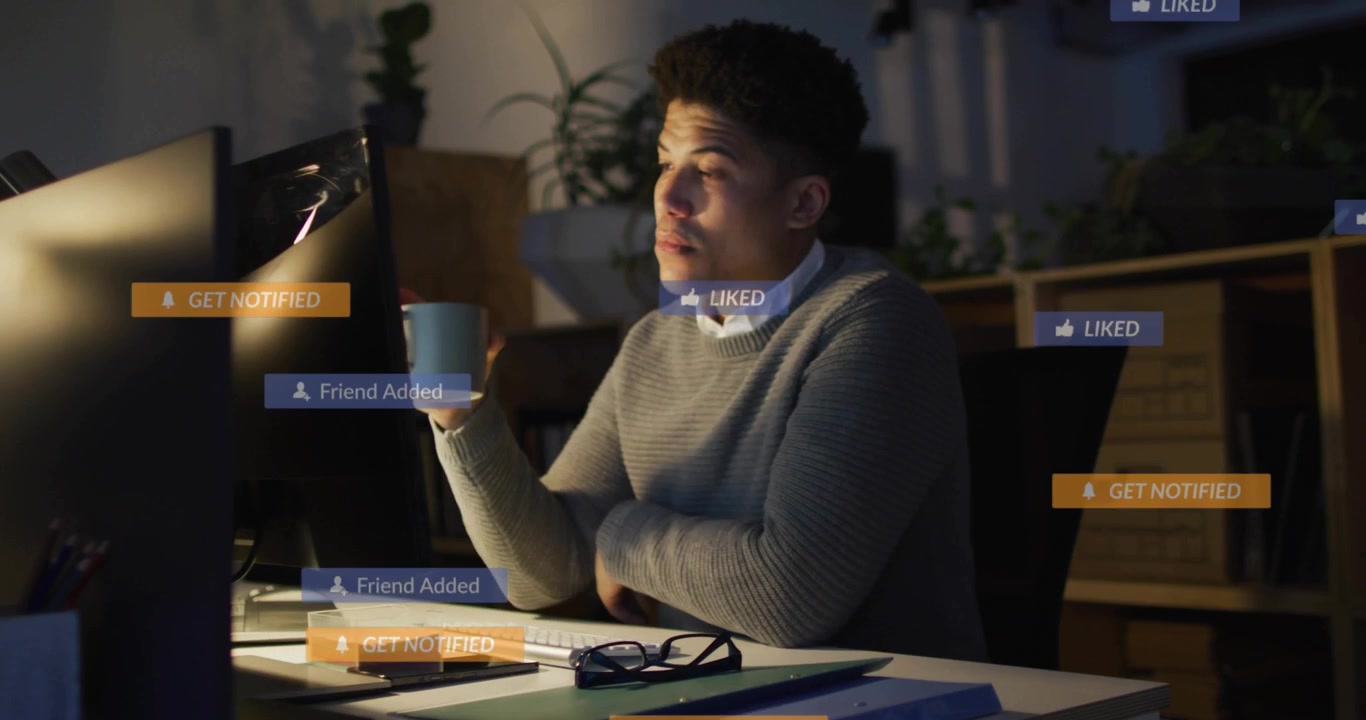 Ung mand overvældet af notifikationer fra sociale medier på computeren
