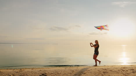 carefree young woman running on the beach with a kitesteadicam slow motion shot