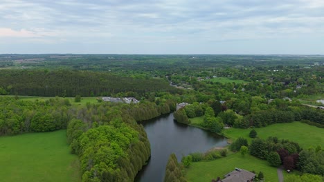 green landscape, aerial view of forests, lake, and suburban homes in alton, ontario