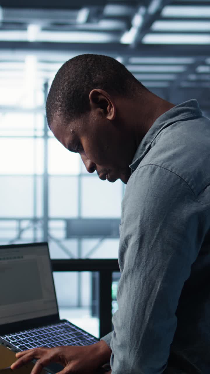 Vertical video Engineer in data center operating notebook, deploying new server architectures