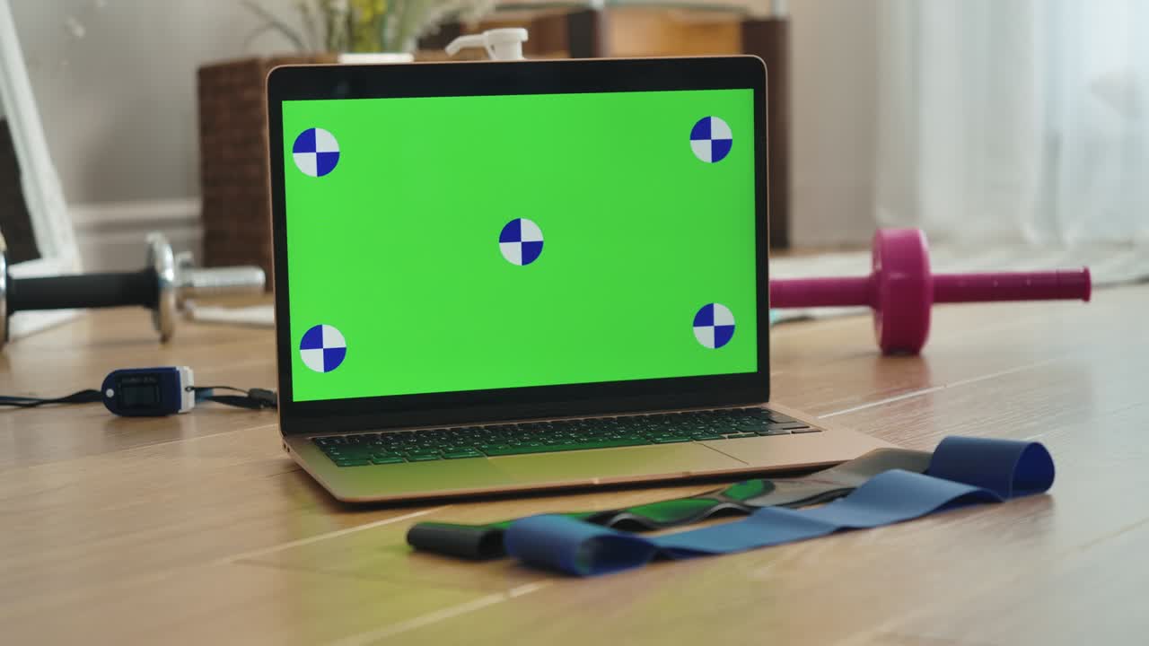 pantalla de portátil chromakey con mano femenina tomando una de las bandas de resistencia tendidas en el suelo. entrenamiento de mujer deportista caucásica irreconocible en casa usando página web en línea. cine 4k prores hq.