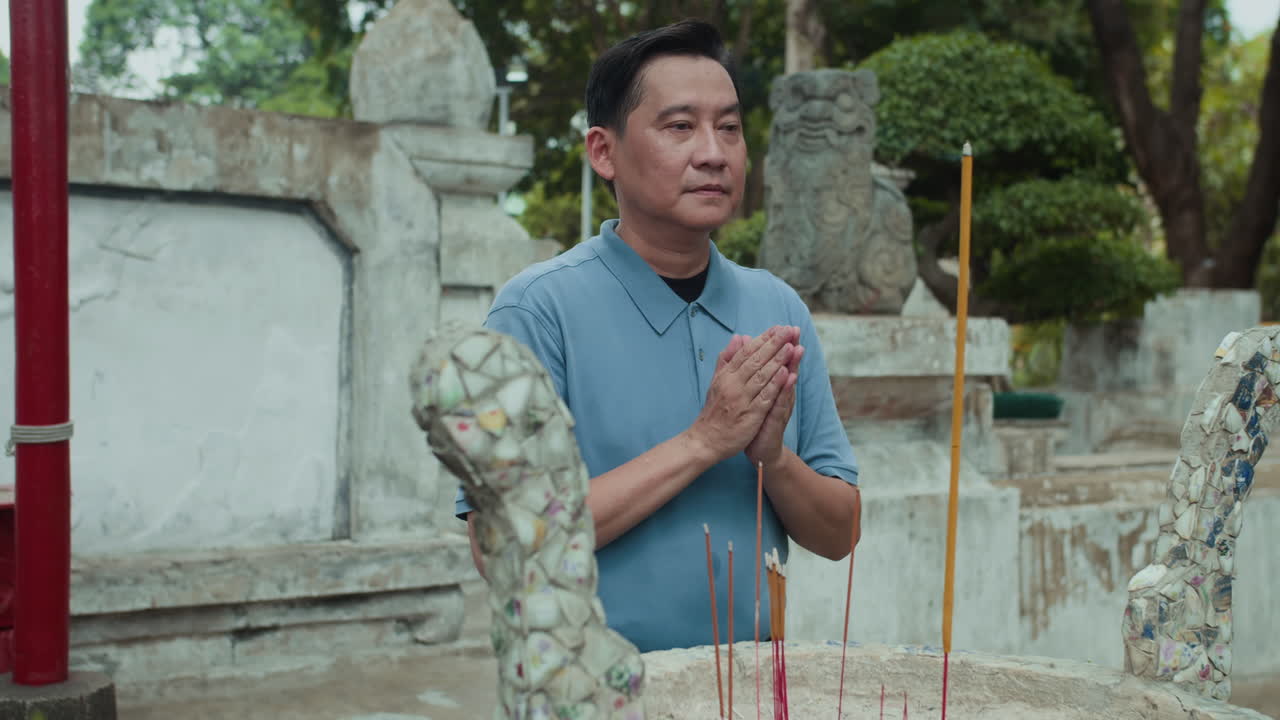 Middle-aged Man Praying by Altar in Holy Place Outdoors