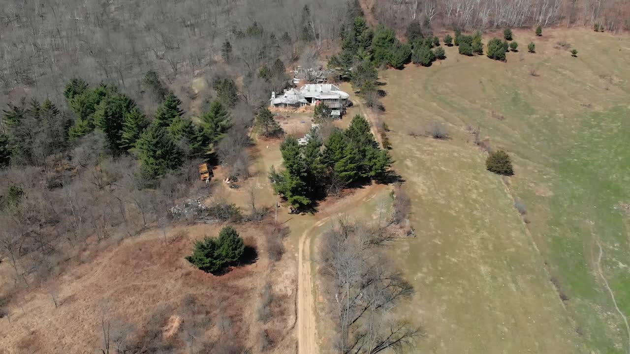 Drone flys up a pathway to reveal a homestead in rural Wisconsin.