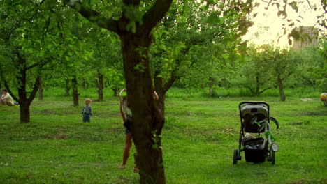 joyful mother and kids spending time outdoors. family playing with ball in park