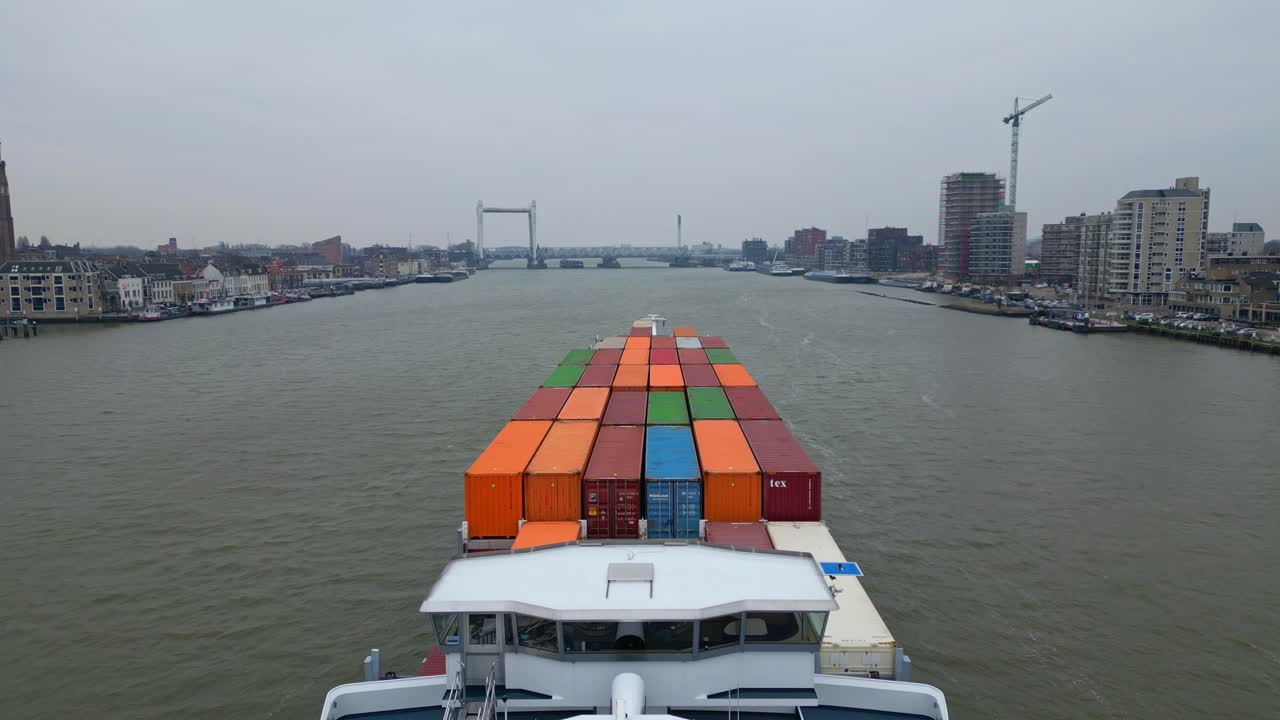 vista aérea sobre la cubierta de un buque portacontenedores que viaja a lo largo de oude maas en un día nublado en dordrecht
