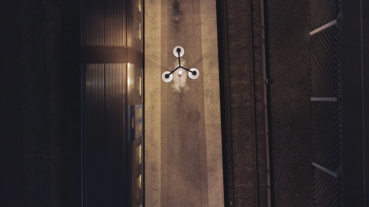 вид с воздуха на поезд метро, прибывающий на платформу