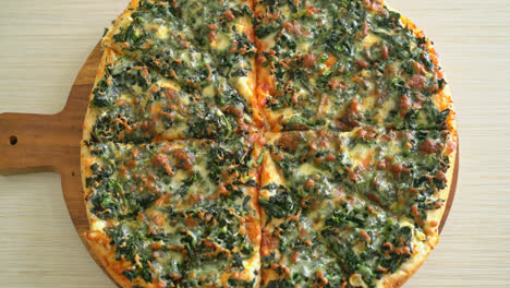 pizza de espinacas y queso en bandeja de madera - estilo de comida vegana y vegetariana