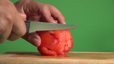 hands dicing a tomato on a chroma background