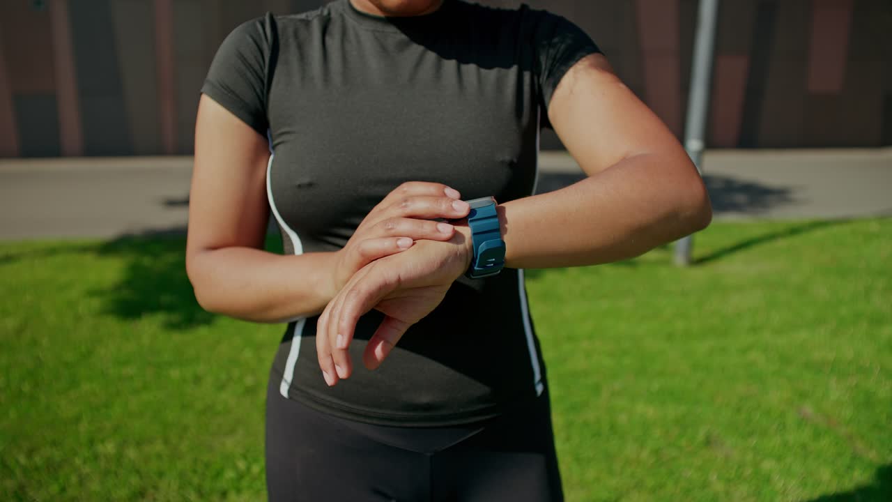 Woman checking her smartwatch during outdoor workout