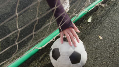 mujer tomando una pelota de fútbol