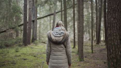 slow motion: young woman enjoys her walk in the forest