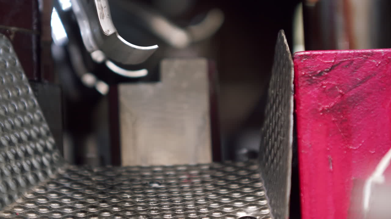 Close up of the inside of a hydraulic press shaping raw car parts in an automated production factory