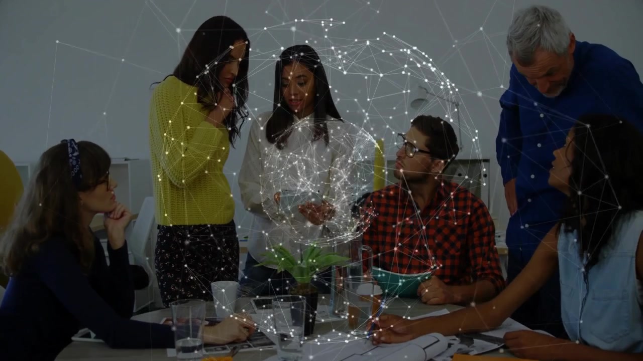 Team tecnologico al tavolo, con un globo olografico che appare sopra una pianta, mentre si chinano in avanti discutendo i dati.