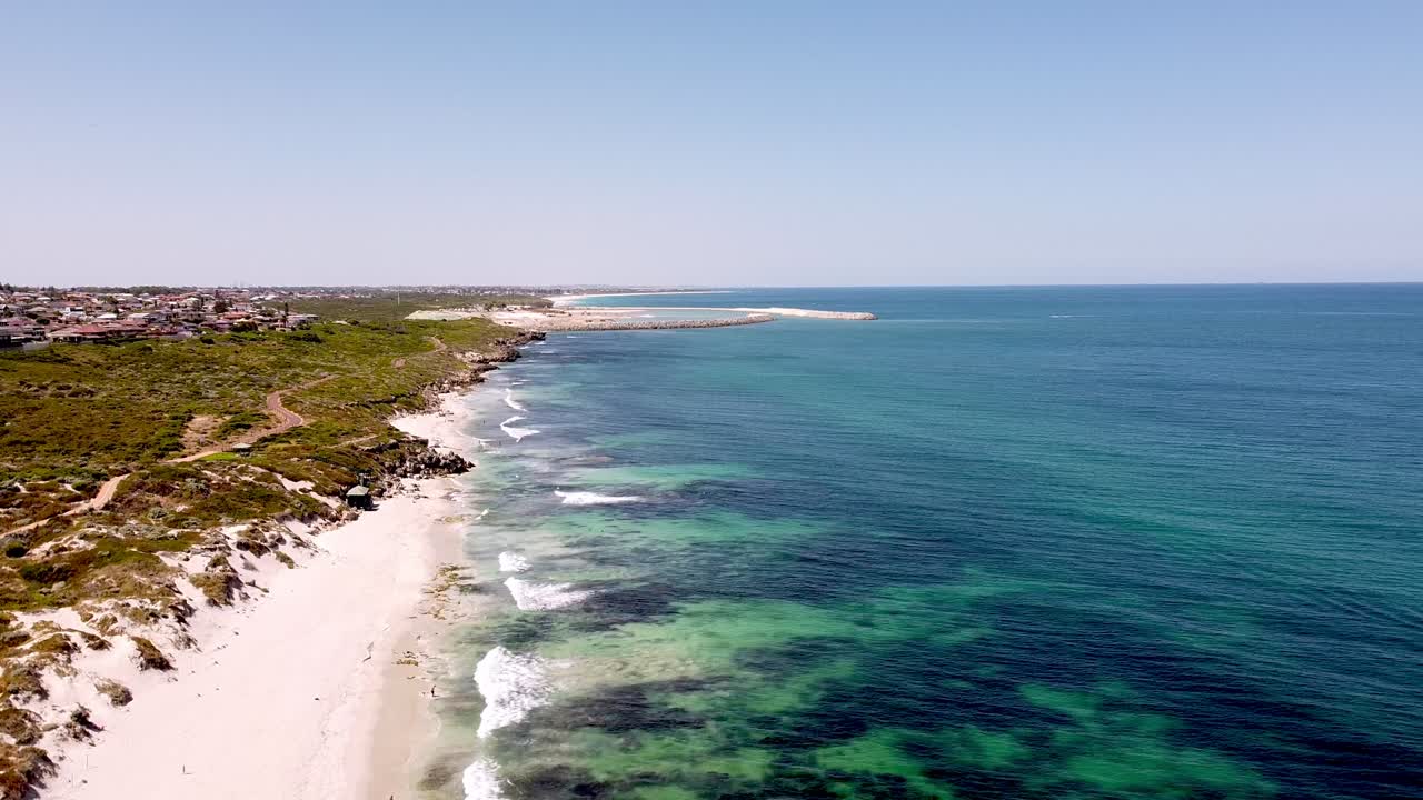 personas disfrutando de la arena blanca y el mar azul profundo en el arrecife oceánico, aérea