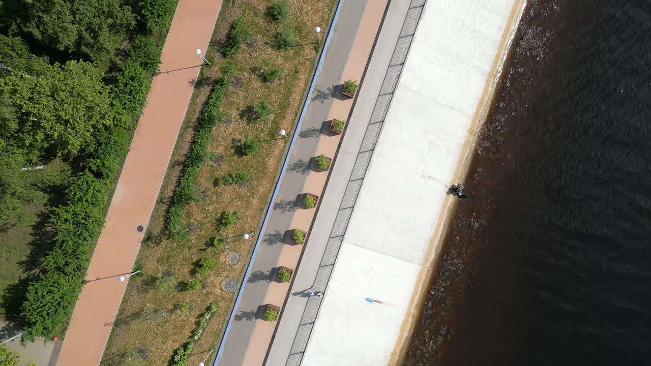 Aerial Top-Down View of a Riverside Promenade with Walkways and Greenery
