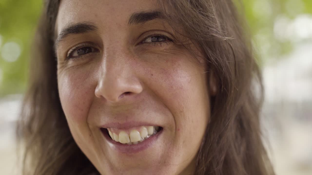 disparo en primer plano de una mujer de mediana edad sonriente mirando a la cámara