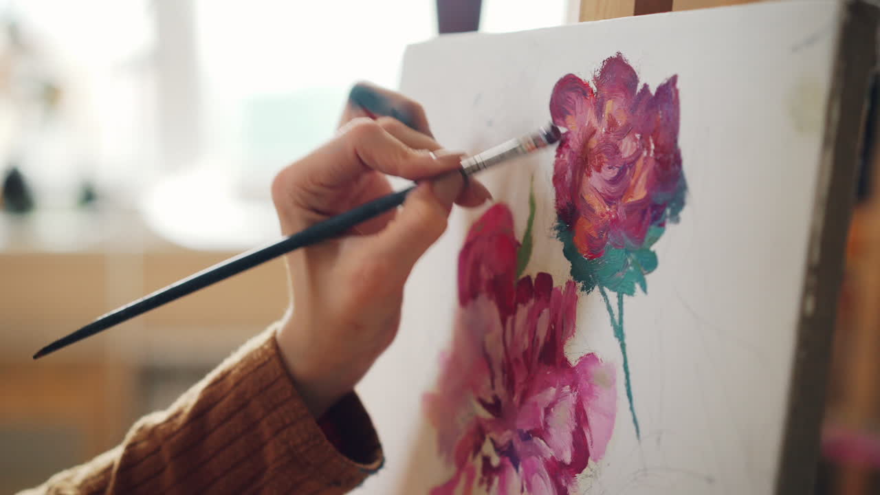 Person painting a flower painting in a studio