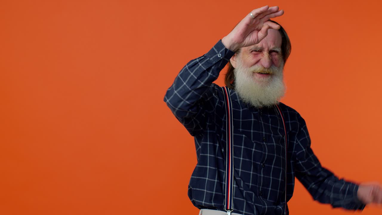 성숙한 은 할아버지 남자가 장난스러운 어리석은 얼굴 표정을 하고, 미소 짓고, 속이고, 혀를 보여줍니다.