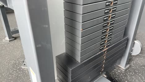 close-up of a weight stack in motion at a bangkok gym. the video captures the weights being lifted and lowered