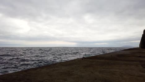 Low-Angle-Motionlapse-Von-Grauen-Wolken,-Die-über-Den-Ozean-An-Der-Promenade-Von-Kapstadt-Rollen