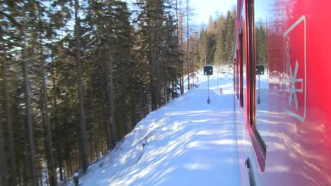 a pov shot from the side of a train as it moves through a snowy landscape