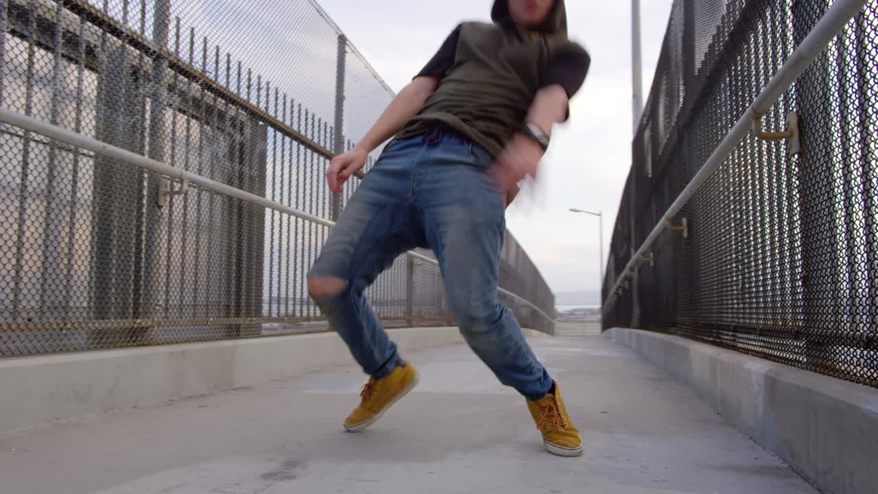 Uomo che balla hip hop freestyle su un cavalcavia autostradale in città