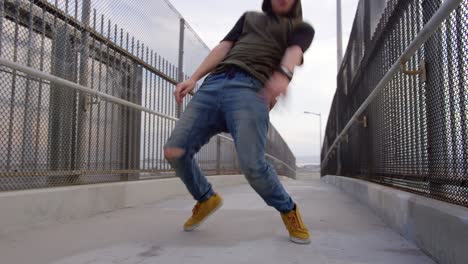 man freestyle hip hop dancing across freeway overpass in city