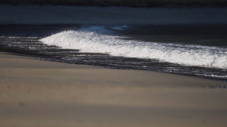 Waves rolling on the sandy shore. Slow-motion