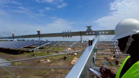 ingeniero profesional midiendo el ángulo de inclinación de las estanterías de módulos solares en el campo utilizando un transportador digital