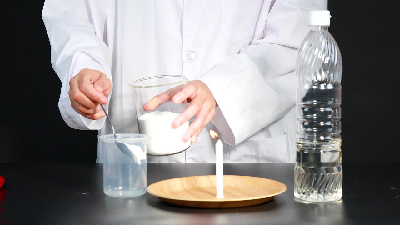 한 과학자 는 실험실 에서 베이킹 소다 와 식초 를 사용 하여 불 의 불꽃 을 끄기 위해 화학 반응 을 시연 한다