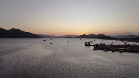 바다와 산을 볼 수 있는 보트와 해가 지는 것을 촬영하는 측면으로 날아다니는 영화적인 항공 영상, 팔라완, 필리핀, 아시아, 드론